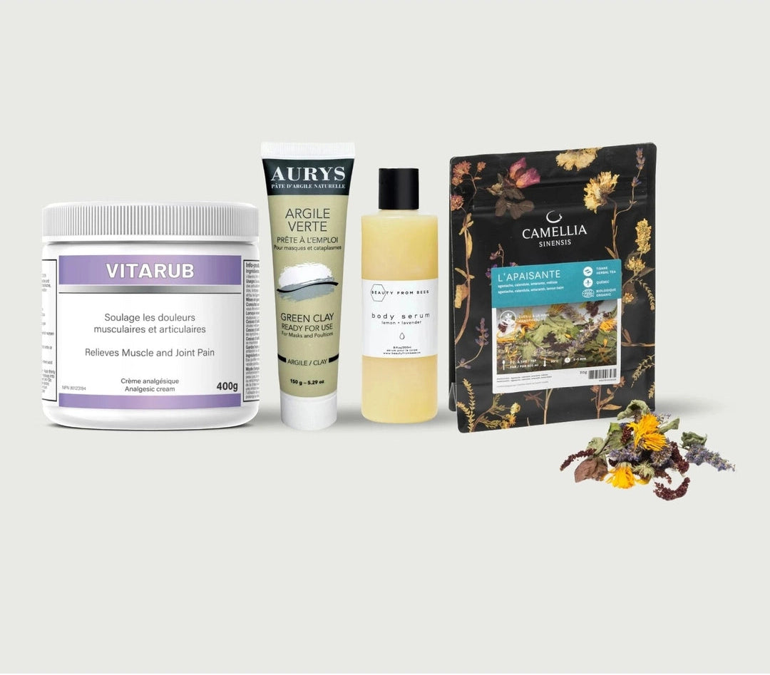 Four wellness products arranged on a light gray background: a white jar labeled VITARUB, a white tube labeled AURY'S GREEN CLAY, a pale yellow bottle labeled BODY BREATHE, and a black stand-up pouch labeled CAMELLIA SUCRARE. A small cluster of dried flowers sits in front of the products.